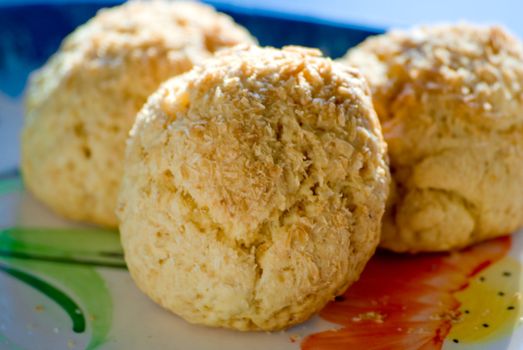 Three cookies with coconuts on a plate.