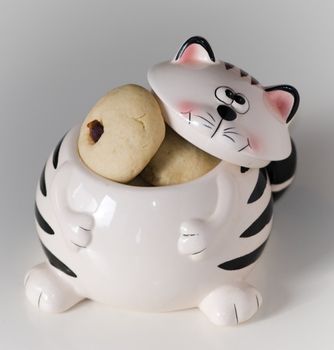 Cookies in cat shape jar on white background