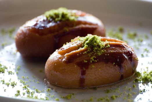 A sweet pastry with syrup and pistachio nut.