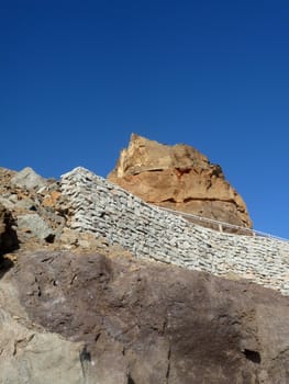 Some costal Cliffside rock against a blue sky.