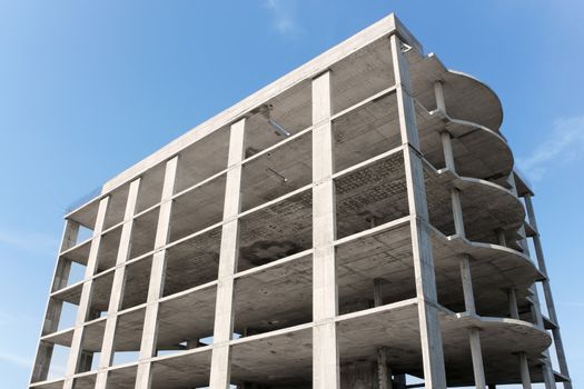 A multi-storey building construction on the background of blue sky