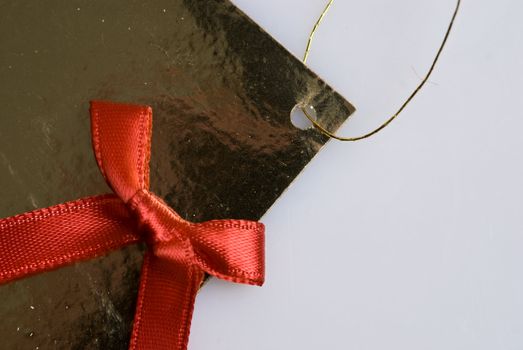 red ribbon tied in a bow on gold gift bag