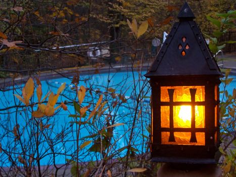 Wrought iron lantern in garden, empty pool in background