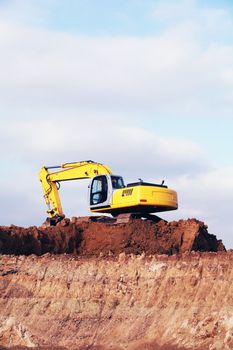 Yellow heavy earth mover digging the soil