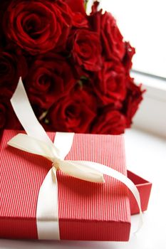 Gift box over bunch of red roses