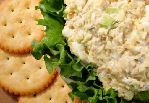 Tuna salad in a bowl with lettuce and crackers