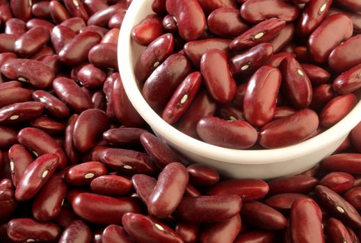 A close up of a measuring cup full of red beans.