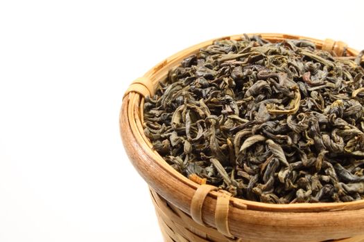 Green tea leaves in a bamboo tea strainer.