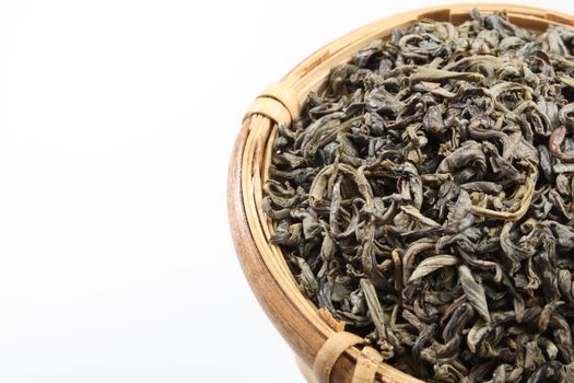 Green tea leaves in a bamboo tea strainer.