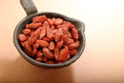 Organic Goji berries in a cast iron spoon.