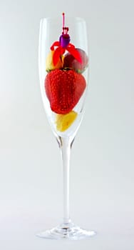 Mix of fruits in an elegant glass, with flower on top