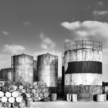 Factory view with tower and oil drums in outdoor with black and white tone.