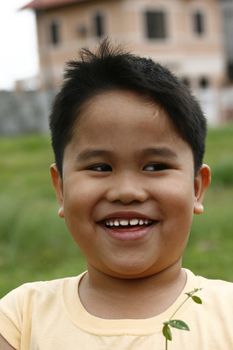 Environmental portrait of Asian Boy In Play ground At Garden