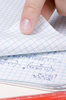 Student folding a page in a math notebook.