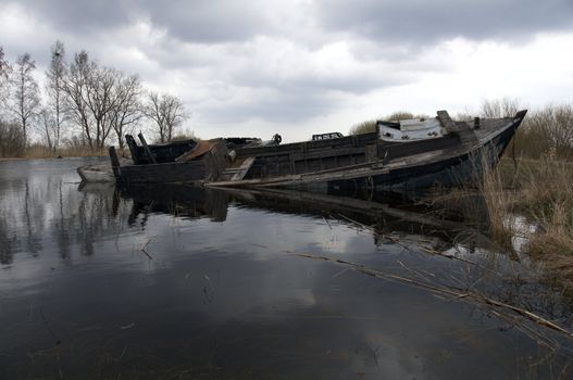 Sunken boat in the bay with clouds above