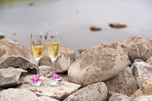 bride and groom wine glasses on rocky beach