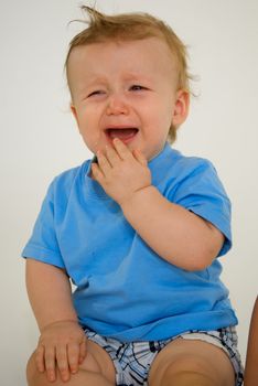 Little red headed boy with blue shirt crying