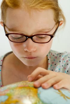 Smart Little Girl Studies Globe with Her Glasses On