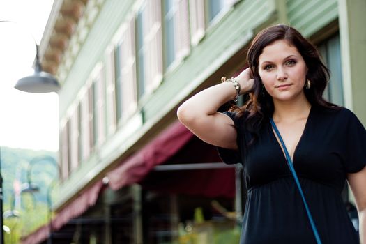 A pretty young brunette woman walking in the city. 