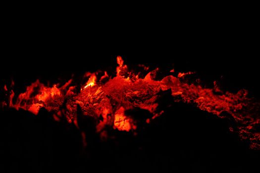 Close view of fire glowing coal on a form of a visual crack on the earth.