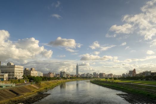 City skyline in Taipei with famous landmark 101 skyscraper and reflection on river in afternoon in Taiwan.