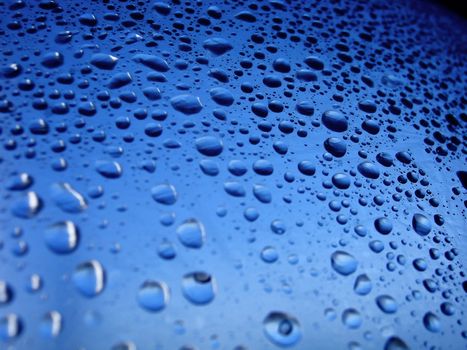 several water drops on a plastic surface with blue tones.