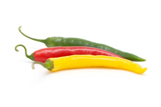 Coloured chili peppers on a white background