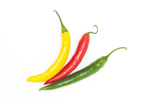 Coloured chili peppers on a white background