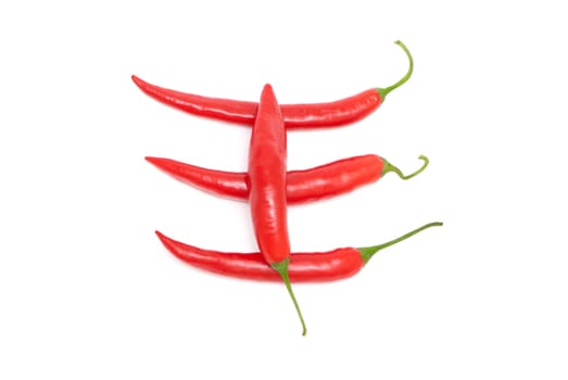Four red hot chili peppers on a white background
