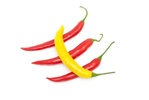 Color chili peppers diagonally on a white background