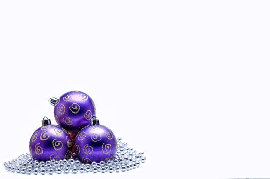 Purple Christmas Baubles with silver beads on white background.