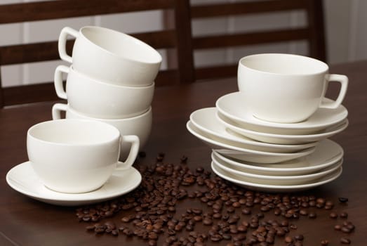 Cups for coffee with coffee grains on a dark wooden table