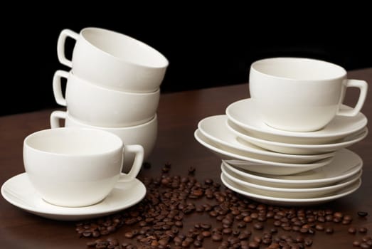 Cups for coffee with coffee grains on a dark wooden table