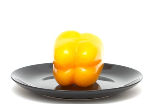 Fresh yellow pepper on a black plate