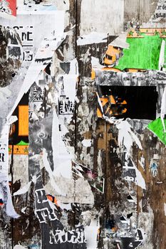 View of a wooden boarded wall with torn publicity paper.