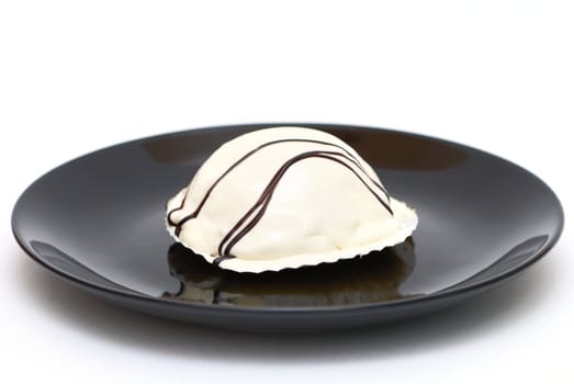 White cake on a black plate isolated on white