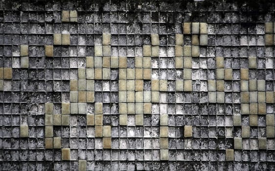 Old fractured and tiled textured wall, with missing tiles. 