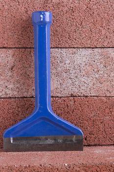 Stonemason's chisel on a background of red bricks.