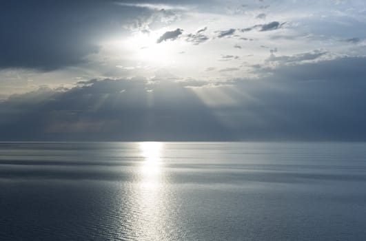 Sunbeams emanating from behind a clouds at sunset