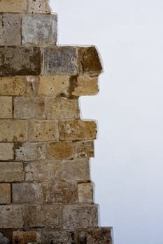 Close up view of a division on a white painted wall and a brick wall.