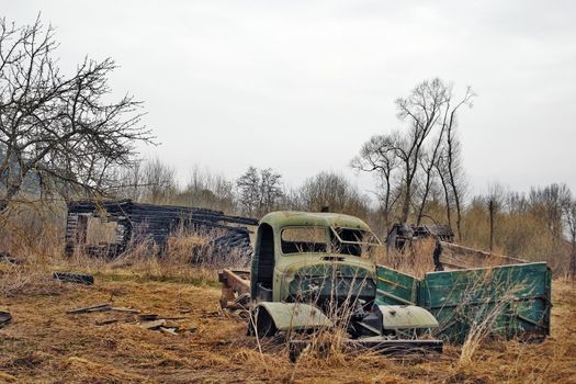 Rural landscape with the burnt down house and the lost broken car