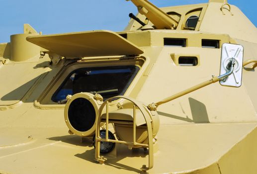 Headlights, a rear-view mirror and a driver window  of an armoured troop-carrier close up