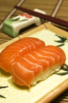 Fresh sushi and chopsticks on disk onbamboo mat 