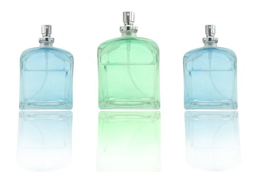 low level angle capturing three perfume bottles arranged over white and reflecting into foreground.