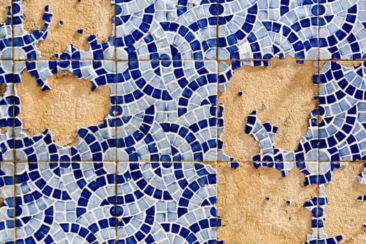 Close up view of a broken tiled wall of small azulejo.