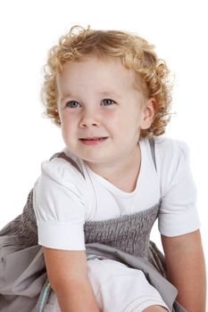 Small blond three year old girl sitting on white background