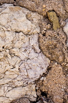 Close up view of a worn textured stone wall.