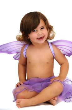 little girl with purple angle wings sitting in studio and smiling