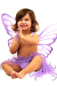 little girl with purple angle wings sitting in studio and smiling