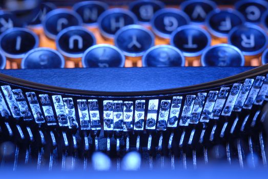 Closeup of old typewriter keys and fonts in blues and orange